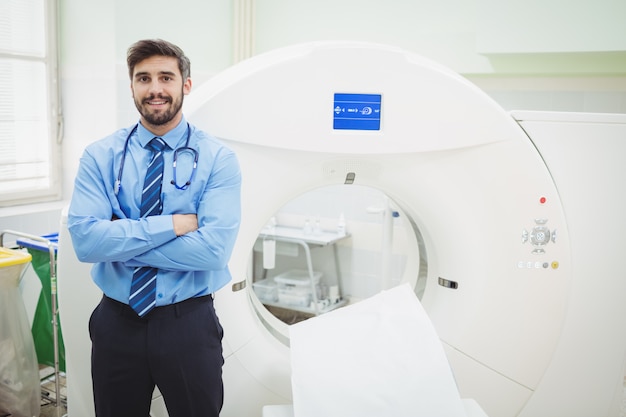 Foto retrato do médico em pé perto do scanner de ressonância magnética