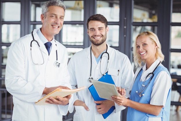 Retrato do médico senior sorridente com colegas de trabalho