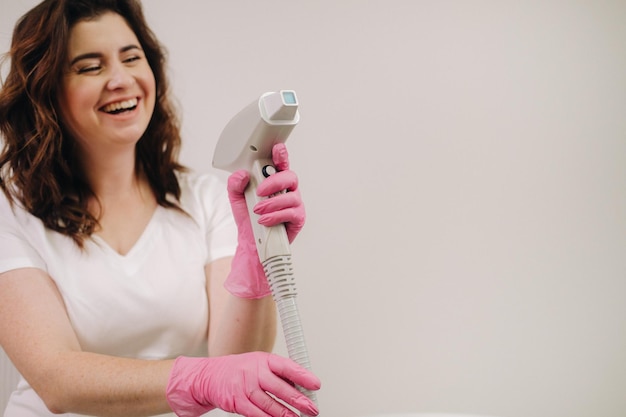 Retrato do mestre da depilação a laser, uma mulher de casaco branco segura um devi de depilação a laser