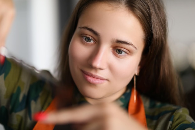 Retrato do mestre de mulher morena no salão de beleza corte de cabelo com envolvimento total. Cabeleireiro cria uma nova imagem da moda para o cliente. Beleza, conceito de moda