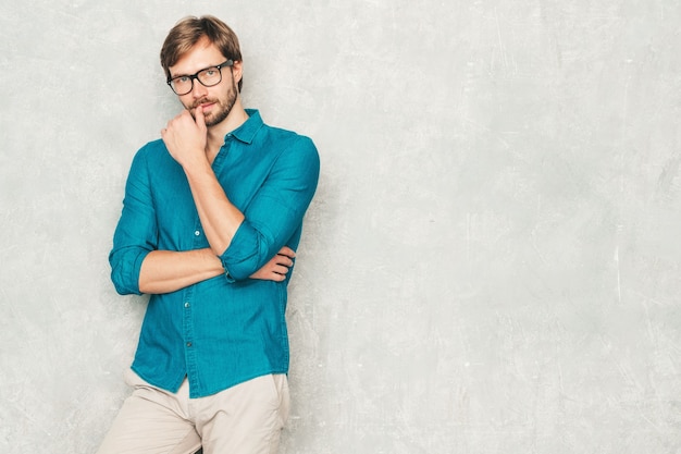 Retrato do modelo de empresário lumbersexual bonito hipster confiante vestindo roupas de camisa jeans casual.