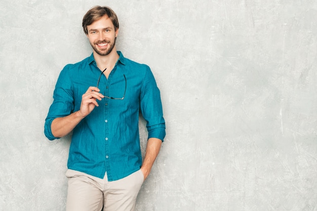 Retrato do modelo de empresário lumbersexual bonito hipster confiante vestindo roupas de camisa jeans casual.