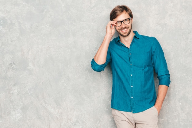 Retrato do modelo de empresário lumbersexual hipster sorridente bonito, vestindo roupas de camisa jeans casual.