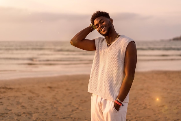 Retrato do modelo de etnia negra aproveitando as férias de verão à beira-mar sorrindo e curtindo à beira-mar
