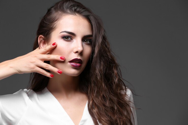 Foto retrato do modelo de mulher jovem e bonita com maquiagem brilhante em fundo escuro