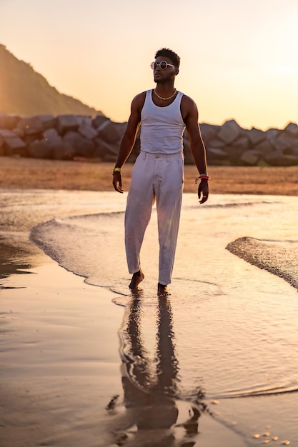 Retrato do modelo étnico negro aproveitando as férias de verão à beira-mar vestindo uma blusa