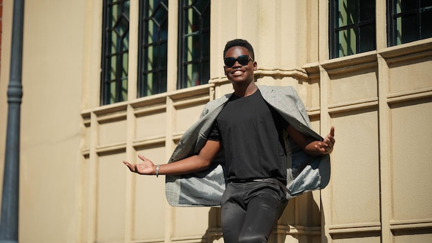 Retrato do modelo jovem atraente elegante homem afro-americano posando em roupas casuais contra um fundo neutro muito sexy com cabelo afro. Em pessoas juventude beleza e conceito de moda.