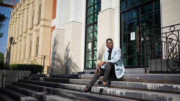 Retrato do modelo jovem atraente elegante homem afro-americano posando em roupas casuais contra um fundo neutro muito sexy com cabelo afro. Em pessoas juventude beleza e conceito de moda.