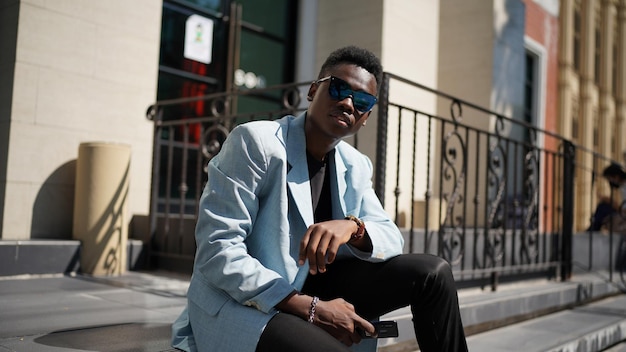 Retrato do modelo jovem atraente elegante homem afro-americano posando em roupas casuais contra um fundo neutro muito sexy com cabelo afro. Em pessoas juventude beleza e conceito de moda.