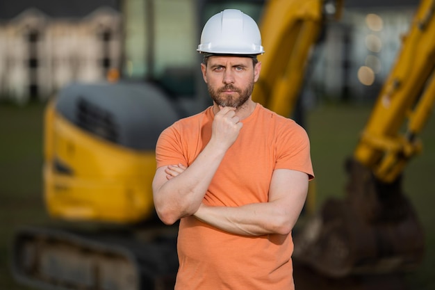 Retrato do trabalhador da construção civil do pequeno empresário com capacete de capacete no canteiro de obras