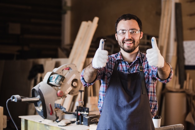 Retrato do trabalhador da construção civil sorridente polegar para cima