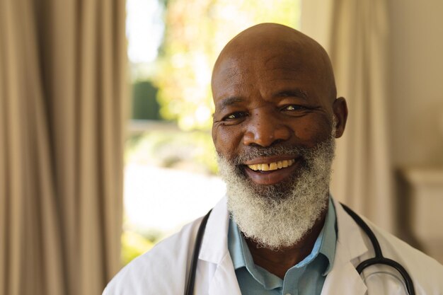 Retrato de un doctor afroamericano mayor sonriente con bata de laboratorio