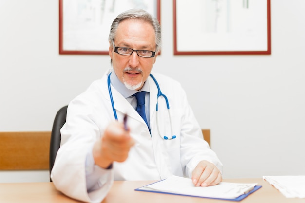 Retrato de un doctor apuntando su pluma a un paciente