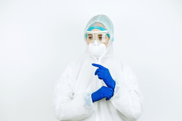 Retrato del doctor cansado después del turno en el hospital. Doctor en ropa protectora. gafas, máscara, guantes en blanco. médico que trata a pacientes con coronavirus. Covid-2019