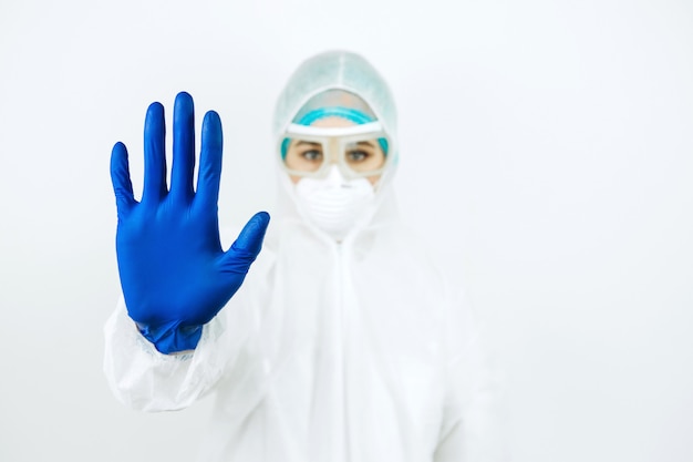 Retrato del doctor cansado después del turno en el hospital. Doctor en ropa protectora. gafas, máscara, guantes en blanco. médico que trata a pacientes con coronavirus. Covid-2019