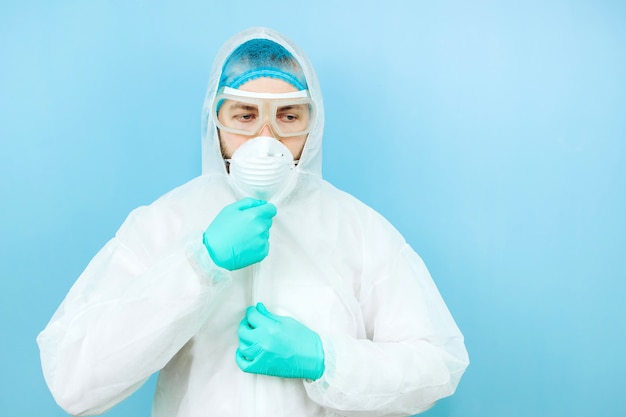 Retrato del doctor cansado después del turno en el hospital. El médico con ropa protectora: gafas, máscara, guantes. El médico trata a pacientes con coronavirus. Covid-2019