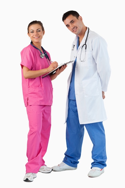 Retrato de un doctor hablando mientras una enfermera toma notas