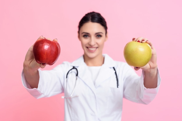 Retrato del doctor de sexo femenino sonriente con el estetoscopio y la manzana