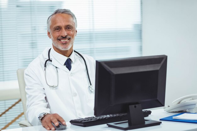 Retrato del doctor trabajando en su computadora en la cabina