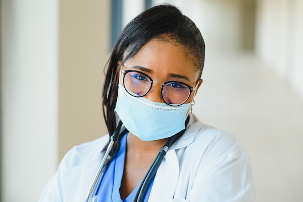 Retrato de doctora afroamericana en máscara protectora en el hospital