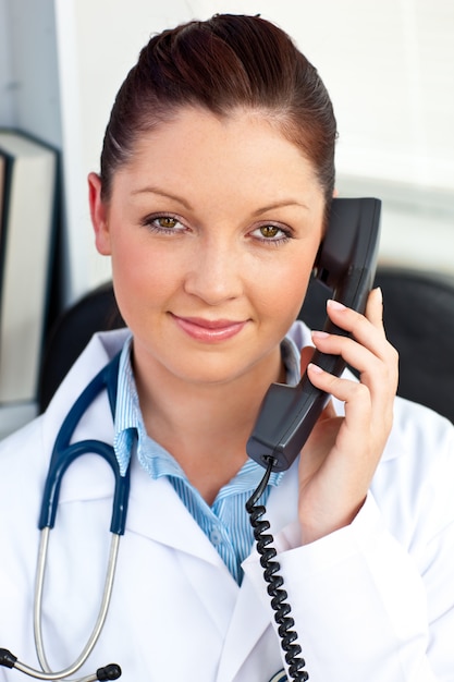 Retrato de una doctora asertiva llamando en su oficina