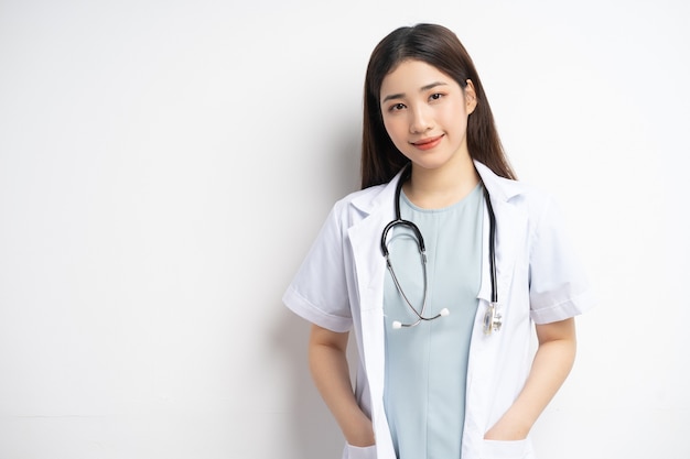 Retrato de la doctora asiática sonriendo sobre fondo blanco.