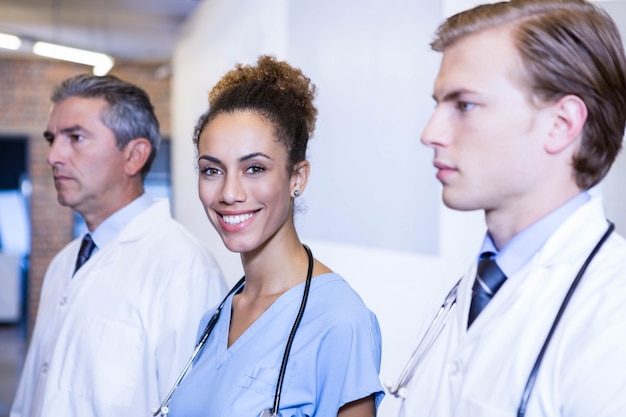 Retrato de doctora y colegas a su alrededor en el hospital