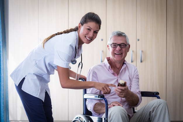 Retrato de doctora dando medicina al hombre senior