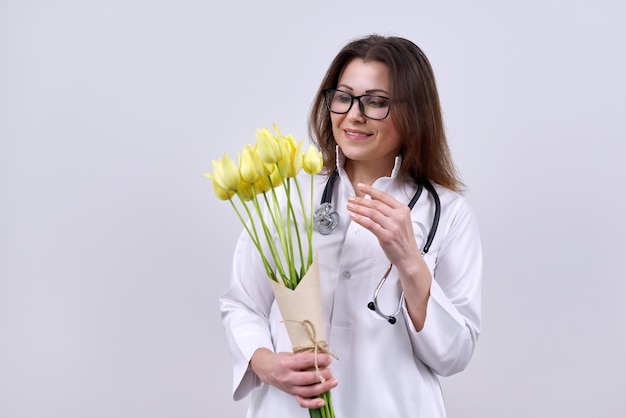 retrato, de, doctora, con, estetoscopio, tenencia, ramo de flores