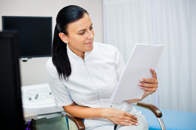 Retrato de una doctora con un historial médico en sus manos