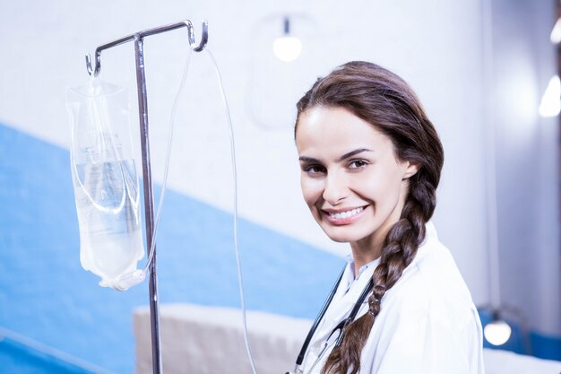 Retrato de doctora llevando soporte salino en el hospital