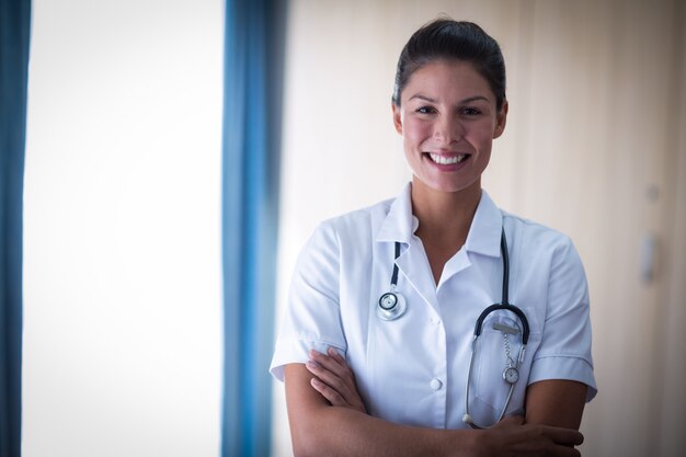 Retrato de doctora de pie con los brazos cruzados