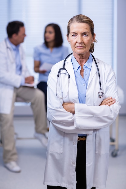 Retrato de doctora de pie con los brazos cruzados