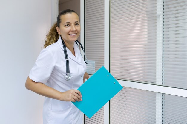 Retrato de doctora positiva, en el hospital cerca de la puerta