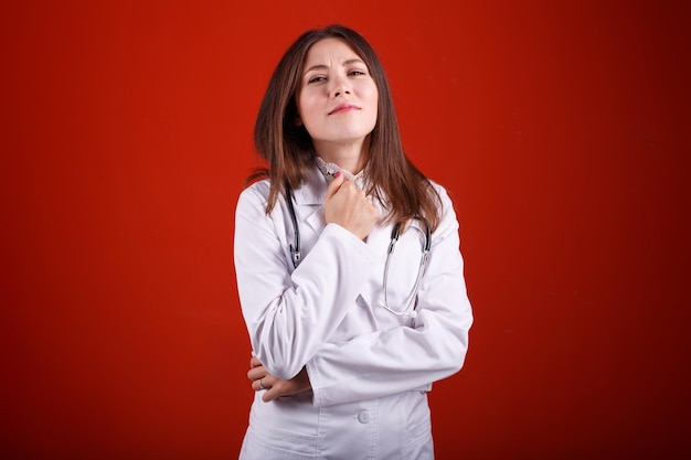 Retrato de una doctora sobre un fondo rojo.