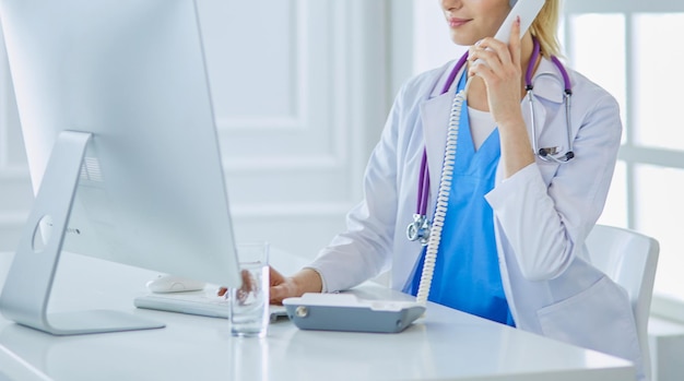 Retrato de doctora usando su teléfono móvil en la oficina