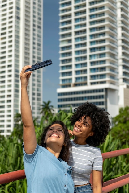 Retrato de dos amigas latinas tomando selfie en la ciudad de Panamá Panamá