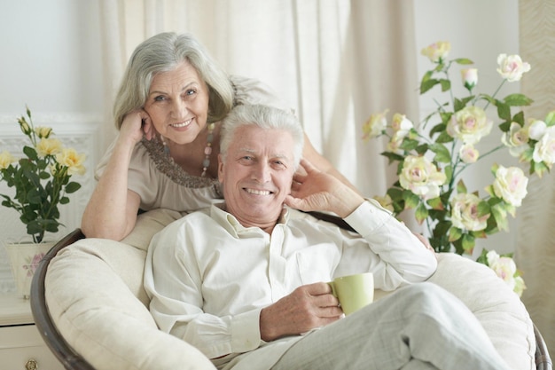 Retrato de dos ancianos descansando en casa con té