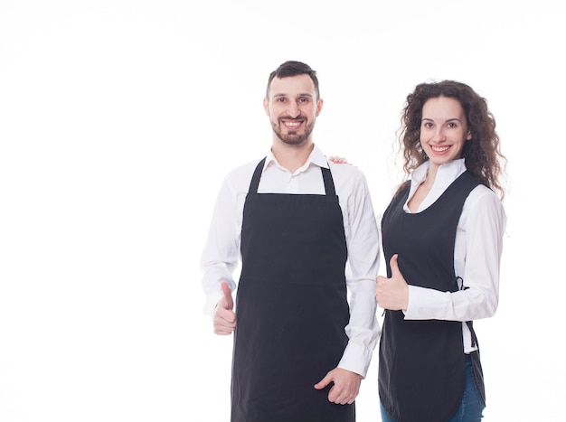 Retrato de dos camareros en el fondo blanco. Pareja trabajando en la cafetería.