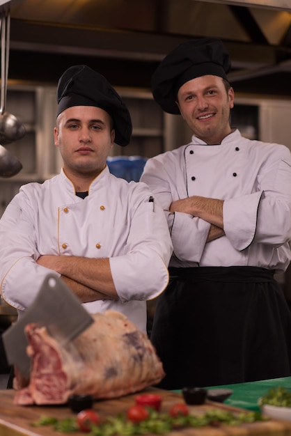 Retrato de dos chefs parados juntos en la cocina comercial en el restaurante