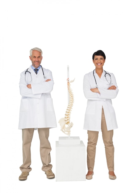 Retrato de dos doctores sonrientes con modelo de esqueleto