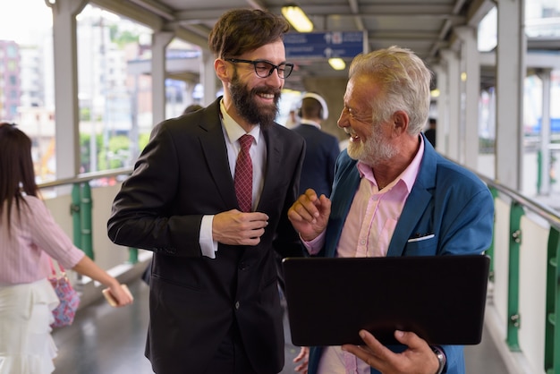 Retrato de dos empresarios barbudos multiétnicos juntos alrededor de la ciudad de Bangkok