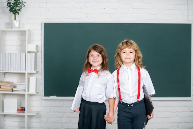 Retrato de dos escolares felices estudiando en el aula en la escuela primaria concepto de amistad a