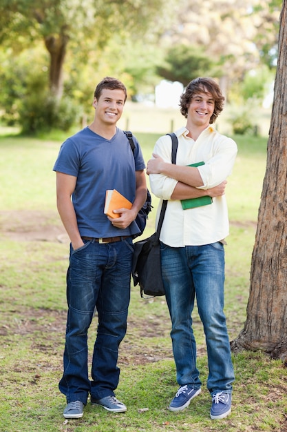 Retrato de dos estudiantes masculinos de pie felices