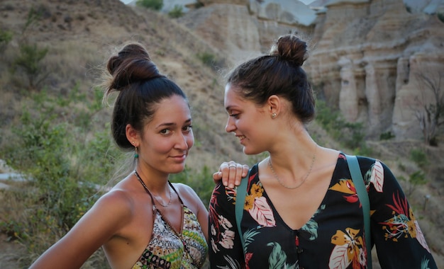 Foto retrato de dos hermanas caucásicas divirtiéndose durante las vacaciones en la montaña en verano