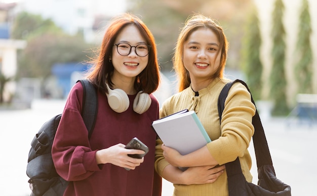 Retrato de dos hermosas estudiantes universitarias asiáticas en la escuela