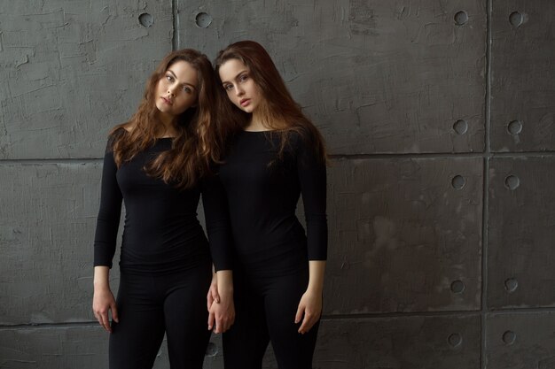 Retrato de dos hermosas hermanas gemelas con maquillaje