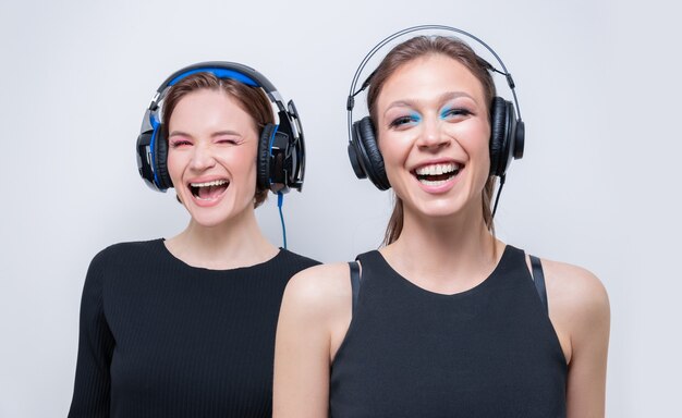 Retrato de dos hermosas mujeres con auriculares. Concepto de soporte técnico. Técnica mixta