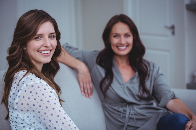 Retrato de dos hermosas mujeres sentadas en el sofá