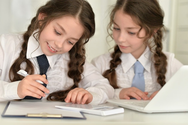 Retrato de dos hermosas niñas haciendo los deberes